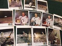Twelve first day covers laid out showing astronaut portraits, paraphernalia, and moon landing scenes