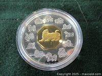 Close-up view of the 1998 Royal Canadian Mint 34 gram sterling silver coin with 24K gold plated tiger in center and surrounding Chinese zodiac animals in silver.