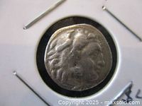 Obverse side of the coin in cardboard flip, showing Heracles portrait.