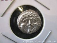 Front side of the silver drachm coin showing the Gorgon Medusa face in relief.