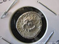 Close-up image of the coin's obverse side showing the head of Medusa with serpentine hair.
