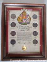 Full view of framed Canadian commemorative one dollar coin collection with nine coins and descriptive background in wood frame with red matting.