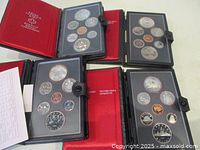Four Royal Canadian Mint coin sets displayed open showing coins from penny to silver dollar in uncirculated condition.