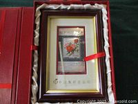 Photo of framed silver stamp in red presentation box with satin lining and securing ribbon