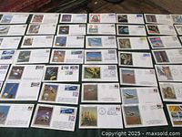 Wide view showing 63 USA space program and aeronautical first day covers arranged on the floor