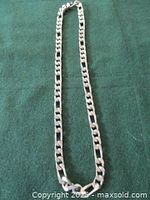 Full length view of vintage chunky solid sterling silver necklace laid on green fabric, clasp visible at top.