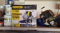 Photo of the Champion Household Water Pump box with product image and specifications visible, along with some cans in background.