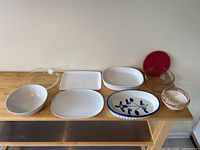 All 8 dishes displayed on wooden surface showing variety of materials and sizes