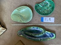 Top view of the three ceramic Art Deco ashtrays arranged on carpet. Includes ruler and auction tag for scale.