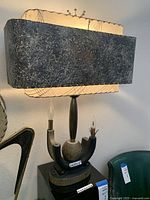 Lamp illuminated on black acrylic stand showing overall appearance