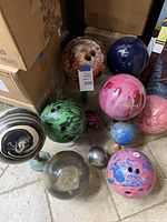 Photo showing the full collection of 10 bowling balls with various colors, patterns and sizes.