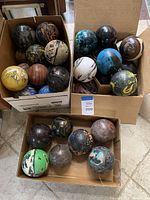 Overview of all decorative marbled balls placed in three cardboard boxes. Each ball exhibits various swirled, marbled colors and patterns.