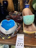 Group of mostly glass decorative bowls and vases including multicolored swirled glass bowls and ceramic vases in turquoise and yellow speckled finish.