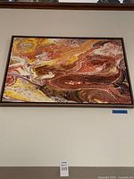 Full frontal view of the framed abstract pour painting hung on wall