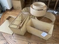 Six lamp shades arranged on hardwood floor showing full lot