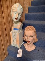 Both mannequin busts displayed on carpeted steps