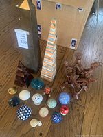 Photo showing three pyramids including tall metal, striped, and wooden pyramids, along with multiple mushroom decor pieces on the floor
