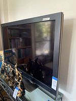 Full side view of the Sharp 52 inch television showing its screen and stand.