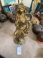 Full view of statue on floor among background items