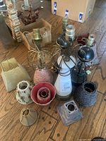 Overview of all lamp bases and lamp shades arranged on floor showing condition and variety