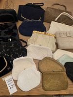 Overview of all 12 assorted vintage purses laid out on table