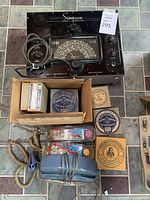 Overview of all items in the lot including the Simpson signal generator, boxes of filter paper, two vintage corded telephones, and two packaged small tools.
