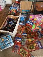 Wide view of box with collection showing loose MOTU figures, carded figures, trading card packs and Star Trek cards