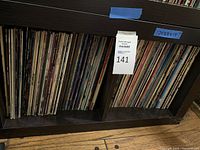 Full bookshelf showing rows of vinyl LPs filling two cubbies