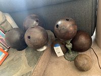 Six wooden balls grouped on floor and two stands propping balls