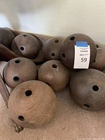 Eight wooden bowling balls arranged on floor and tray