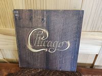 Front cover of Chicago V vinyl LP album showing wood grain background and gold logo