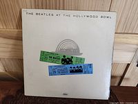 Front cover of The Beatles At The Hollywood Bowl LP showing the embossing and concert ticket graphics
