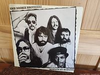 Front cover of The Doobie Brothers Minute By Minute album showing black and white band photo with title text.