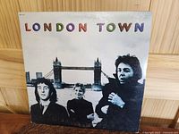 Front cover of Wings 'London Town' LP showing band members and Tower Bridge in background.