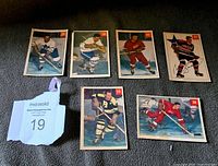 Front view of six Parkhurst 1954 hockey cards laid out on a surface with a MaxSold lot number tag