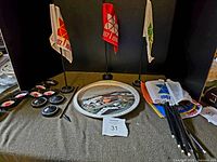 Mid shot of the lot showing all flags with stands arranged behind the tray and badges to left side