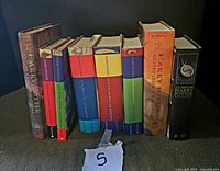 Full view of all nine Harry Potter hardcover books standing upright, showing spines and dust jackets.