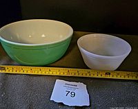 Both mixing bowls side by side with a measuring tape showing size, and lot number paper in front.