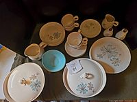 Full set arranged on table, showing all pieces including cups, plates, serving bowls, gravy boat, creamer, and salt/pepper shakers.