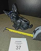 Side view of the black ceramic Scotty dog planter with measuring tape showing approximate length.