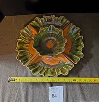 Top-down view of entire 5-piece ceramic serving set with tape measure for size reference, showing center bowl and four surrounding sections with scalloped edges and vibrant green and rust orange drip glaze.