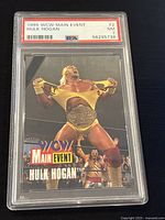 Front of 1995 WCW Main Event Hulk Hogan trading card graded PSA 7 showing wrestler tearing shirt with title and logo