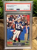 Front view of the 2002 Leaf Rookies and Stars Tom Brady rookie card graded PSA 7 Near Mint, showing Tom Brady in Patriots uniform.
