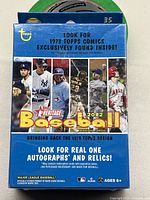 Blue sealed box of 2022 Topps Heritage Baseball trading cards with front label promoting 1973 Topps comic and autographs/relics inside, featuring images of star players including a Yankees player and Mike Trout.