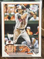 Front of 2023 Gunnar Henderson Orioles rookie card showing player batting image and inset headshot