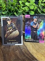 Two Paul Skenes baseball cards side by side, one in Pirates uniform, the other holographic Greatest Hits foil card in blue uniform.