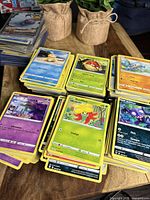 Four stacks of unsleeved base Pokémon cards on wooden table