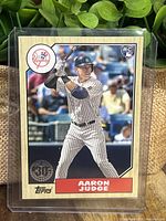 Front of 2017 Aaron Judge Yankees rookie card showing player batting and wood border