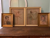 Four framed artworks displayed on wooden surface: two ballet dancers and two portraits.
