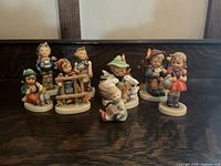 Wide shot of all eight Hummel figurines showing different poses and colors